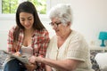 Granddaughter solving crosswords puzzle with the help of her grandmother at home Royalty Free Stock Photo