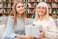 Granddaughter taking care of her retired grandmother gift box Royalty Free Stock Photo