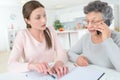 Granddaughter teaching grandma how to use smartphone