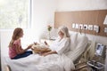 Granddaughter Visiting Grandmother In Hospital Bed For Afternoon Tea Royalty Free Stock Photo