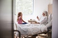 Granddaughter Visiting Grandmother In Hospital Bed For Afternoon Tea Royalty Free Stock Photo