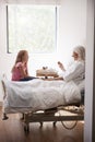 Granddaughter Visiting Grandmother In Hospital Bed For Afternoon Tea Royalty Free Stock Photo