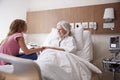 Granddaughter Visiting And Talking With Grandmother In Hospital Bed Royalty Free Stock Photo