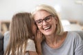 Granddaughter whisper something to granny sharing secret Royalty Free Stock Photo