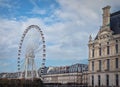 Grande Roue de Paris ferris wheel next to Louvre museum building and parisian houses, France Royalty Free Stock Photo