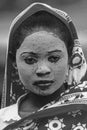 Grandes Comores: A young woman having a sandelwood facial mask on while walking around