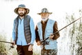 Grandfather with adult son fishing on the lake Royalty Free Stock Photo