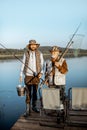 Grandfather with adult son fishing on the lake Royalty Free Stock Photo