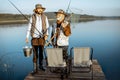 Grandfather with adult son fishing on the lake Royalty Free Stock Photo