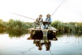 Grandfather with adult son fishing on the lake Royalty Free Stock Photo