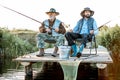 Grandfather with adult son fishing on the lake Royalty Free Stock Photo