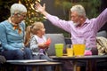 Grandfather amusing his granddaughter, telling story with his arms spread