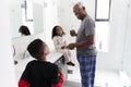 Grandfather In Bathroom Wearing Pajamas Brushing Teeth With Grandchildren