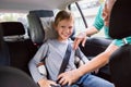 Grandfather Buckling Up On Grandson In Car Safety Seat Royalty Free Stock Photo