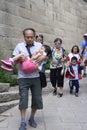 A grandfather carries his tired, young granddaughter on a family outing