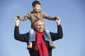 Grandfather Carrying Grandson On His Shoulders