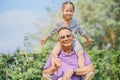 Grandfather carrying his granddaughter on his shoulders Royalty Free Stock Photo