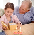 Grandfather child and open gift box, birthday party with celebration for special event and happy family at home. Old man Royalty Free Stock Photo