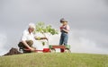 Grandfather and child planting tree in park family togetherness