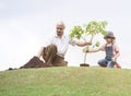 Grandfather and child planting tree in park family togetherness Royalty Free Stock Photo