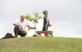 Grandfather and child planting tree in park family togetherness Royalty Free Stock Photo