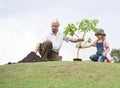 Grandfather and child planting tree in park family togetherness Royalty Free Stock Photo