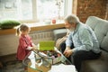 Grandfather and child playing together at home. Happiness, family, relathionship, education concept.