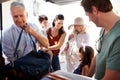 Grandfather and dad packing car boot with holiday luggage, while the family wait close by, close up Royalty Free Stock Photo