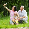 Grandfather, daughter and granddaughter are photographed outdoors.