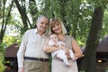 Grandfather with daughter and granddaughter standing in a garden Royalty Free Stock Photo