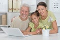Grandfather, daughter and granddaughter using laptop