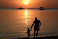 Grandfather and grandson on the beach at sunset. Boracay Island. Western Visayas. Philippines