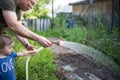 Grandfather is engaged with granddaughter. elderly man and baby hose down potato sprouts in garden