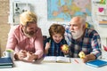 Grandfather father and child son learning at home classroom. Child learning to write and read with parents.