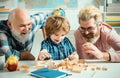 Grandfather father and cute little son having fun at home. Parenting childhood values weekend. Male multi generation Royalty Free Stock Photo