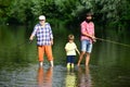 Grandfather, father and grandson fishing together. Coming together. Fly fishing. Father teaching his son fishing against Royalty Free Stock Photo