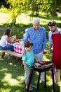 Grandfather, father and son barbequing in the park Royalty Free Stock Photo