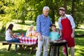 Grandfather, father and son barbequing in the park Royalty Free Stock Photo