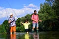 Grandfather, father and son are fly fishing on river. Anglers. Family bonding. Royalty Free Stock Photo