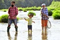 Grandfather, father and son are fly fishing on river. Anglers. Happy fisherman with fishing rod. Happy grandfather and Royalty Free Stock Photo