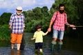 Grandfather, father and son are fly fishing on river. Fly fisherman using fly fishing rod in river. 3 men fishing on Royalty Free Stock Photo