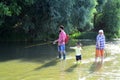 Grandfather, father and son are fly fishing on river. 3 men fishing on river in summer time. Happy grandfather and Royalty Free Stock Photo