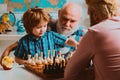 Grandfather father and son playing chess, happy men generations family. Granddad and cute little boy grandson study and Royalty Free Stock Photo