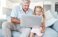 Grandfather, girl and child with laptop on sofa for education, learning or gaming together on internet in home. Senior