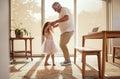 Grandfather, girl and dance holding hands in living room home. Love, smile and happy cute daughter dancing with caring