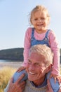 Grandfather Giving Granddaughter Ride On Shoulders As They Walk Through Sand Dunes Royalty Free Stock Photo