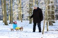 Grandfather with grandchild enjoying winter forest