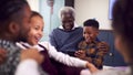 Grandfather With Grandchildren Playing Game On Mobile Phone At Home Royalty Free Stock Photo