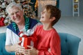 Grandfather and grandchildren in a room decorated for Christmas against the background of a Christmas tree. Royalty Free Stock Photo