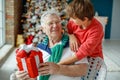 Grandfather and grandchildren in a room decorated for Christmas against the background of a Christmas tree. Royalty Free Stock Photo